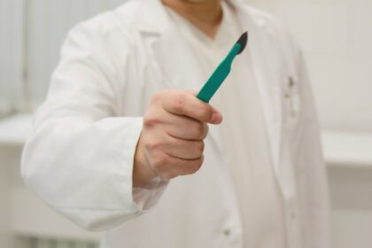 a man in a lab coat holding a toothbrush