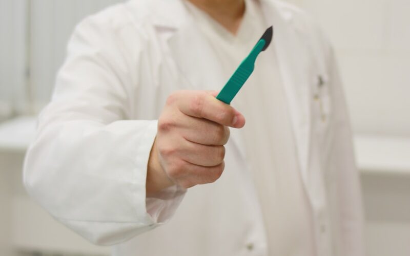 a man in a lab coat holding a toothbrush
